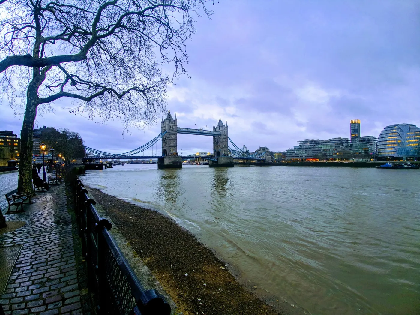 Tower Bridge over the River Thames at dusk, seen from the riverside path